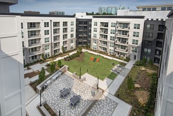 Serene courtyard with outdoor grilling & bistro lighting